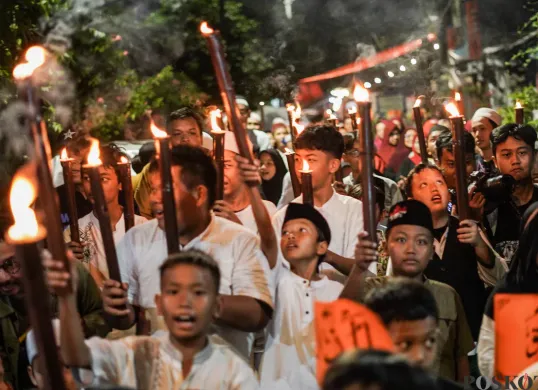 Sejumlah warga mengikuti pawai obor di kawasan Menteng, Jakarta, Kamis, 26 Juni 2025, lalu. Pawai obor tersebut diikuti oleh warga Menteng RW 08. (Sumber: Poskota/Bilal Nugraha Ginanjar)