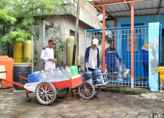 Seorang warga Pulau Kelapa sedang mengisi dan mengantri air dari Brackish Water Reverse Osmosis (BWRO) yang air itu biasa digunakan untuk minum, Jumat, 4 Juli 2025. (Sumber: Poskota/M. Tegar Jihad)