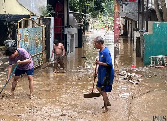 Warga RW 08 Kelurahan Pejaten Timur, Jakarta Selatan, gotong royong membersihkan lingkungan setelah banjir mulai surut pada Minggu, 6 Juli 2025. (Sumber: POSKOTA | Foto: Pandi Ramedhan)