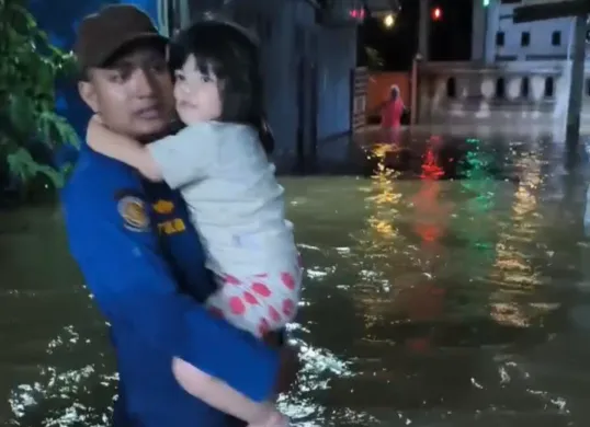 Petugas Damkar UPT Cimanggis mengevakuasi balita di tengah kepungan banjir akibat tanggul kali jebol di Perum Lembah Nirmala 1, Mekarsari, Cimanggis, Kota Depok, Minggu, 6 Juli 2025, malam. (Sumber: Damkar Depok)