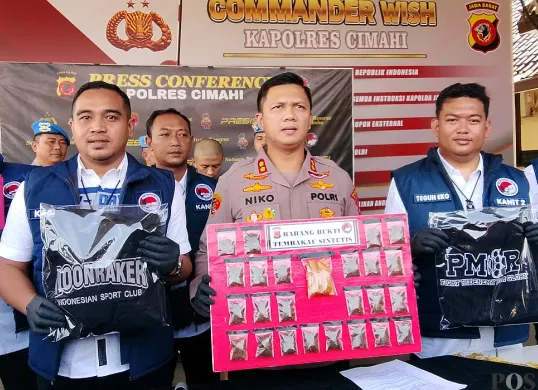 Kapolres Cimahi AKBP Niko Nurullah Adi Putra (tengah) menunjukan barang bukti narkotika jenis tembakau sintetis, Senin 7 Juli 2025. (Sumber: POSKOTA | Foto: Gatot Poedji Utomo)