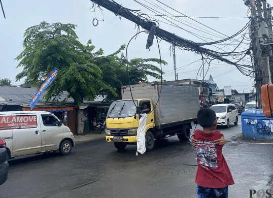 Kondisi kabel semrawut hingga menjulur ke ruas Jalan Haji Mansyur, Kelurahan Gondrong, Kecamatan Cipondoh, Kota Tangerang pada Senin, 7 Juli 2025. (Sumber: POSKOTA | Foto: Primayanti)