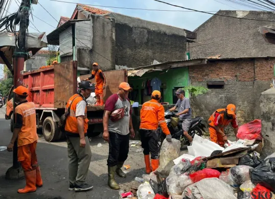 Sejumlah petugas UPS Badan Air sedang menangani sisa sampah banjir di Bidara Cina, Jakarta Timur, Senin, 7 Juli 2025. (Sumber: Poskota/M. Tegar Jihad)