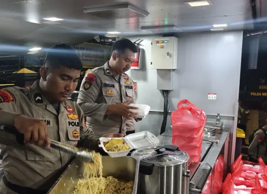 Anggota Pammat Dit Samapta Polda Metro Jaya menyiapkan makanan untuk dibagikan kepada para korban banjir di Cipinang Melayu, Jakarta Timur, Senin, 7 Juli 2025, malam. (Sumber: Polda Metro Jaya)