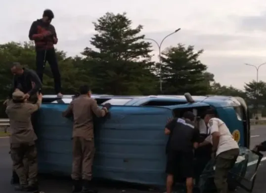 Petugas dan warga mengevakuasi angkot terguling di Tol Jagorawi Km 40.700, Sukaraja, Kabupaten Bogor, Rabu, 9 Juli 2025. (Sumber: Istimewa)