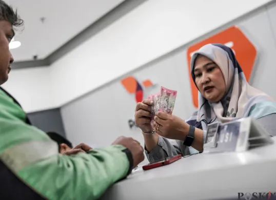 Warga mengambil dana Pencairan Bantuan Subsidi Upah (BSU) tahap 1 di Graha Pos Indonesia, Jakarta, Rabu, 9 Juli 2025. (Sumber: Poskota/Bilal Nugraha Ginanjar)