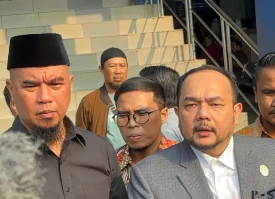 Ahmad Dhani (kiri) dan kuasa hukumnya Aldwin Rahardian (kanan) mendatangi Polda Metro Jaya untuk melaporkan dugaan perundungan terhadap anak perempuannya berinisial SF. (Sumber: POSKOTA | Foto: Ali Mansur)