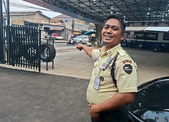 Tri Agus Wiyono, satpam Kantor Pegadaian Bojongsari, Kota Depok, menunjukkan TKP perampokan terhadap nasabah bank dengan modus gembos ban mobil. (Sumber: POSKOTA | Foto: Angga Pahlevi)
