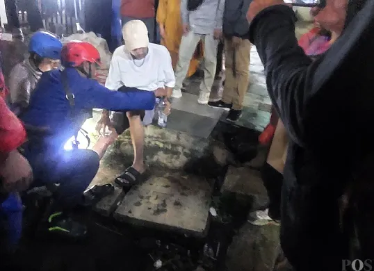 Petugas Damkar Kota Bogor mengevakuasi warga yang kakinya terjepit di rel kereta Stasiun Bogor, Minggu malam, 13 Juli 2025. (Sumber: POSKOTA | Foto: Sekar Putri Andini)