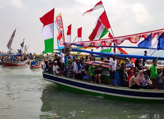 Nelayan di Carita, Pandeglang, saat hendak melakukan larung saji dalam acara ruat laut pada Minggu, 13 Juli 2025. (Sumber: POSKOTA | Foto: Samsul Fatoni)