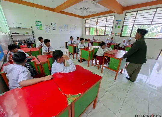 Direktur Sekolah AMEC, H.Mamun Ibnu Ridwan memberikan pemaparan pada 25 murid SMP rintisan gratis dalam kelas, Senin, 14 Juli 2025. (Sumber: Poskota/Angga Pahlevi)