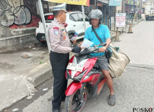 Kanit Lantas Polsek Cimanggis, Iptu Sucipto memberikan teguran kepada pengendara motor  di Jalan Rajawali Samping Tol Cisalak, Cimanggis, Kota Depok, Senin, 14 Juli 2025. (Sumber: Poskota/Angga Pahlevi)