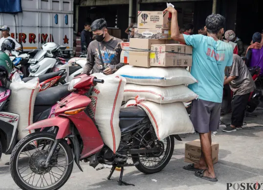 Pekerja mengangkat karung beras di Pasar Beras Cipinang, Jakarta Timur, Selasa, 15 Juli 2025. (Sumber: Poskota/Bilal Nugraha Ginanjar)