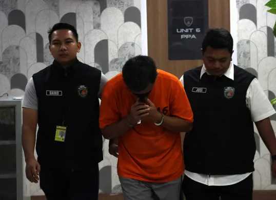 Anggota Polresta Bandara Soetta menggiring IM (tengah), terduga kasus pelecehan seksual terhadap seorang penumpang anak dalam penerbangan pesawat Citilink rute Denpasar-Jakarta. (Sumber: Dok Polres Bandara Soekarno-Hatta)