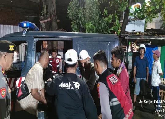 Anggota Polsek Cimanggis dibantu warga amankan dua unit motor Honda Vario hitam dibuang dalam Kali Pal, Cimanggis. (Sumber: Polsek Cimanggis)