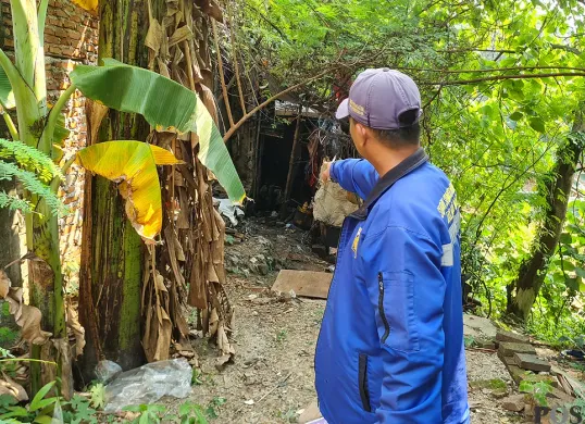 Warga menunjukkan lokasi penemuan jasad laki-laki yang sudah membusuk di sebuah gubuk di bantaran aliran Kali Pesanggrahan, Jakbar, Sabtu, 19 Juli 2025. (Sumber: POSKOTA | Foto: Pandi Ramedhan)