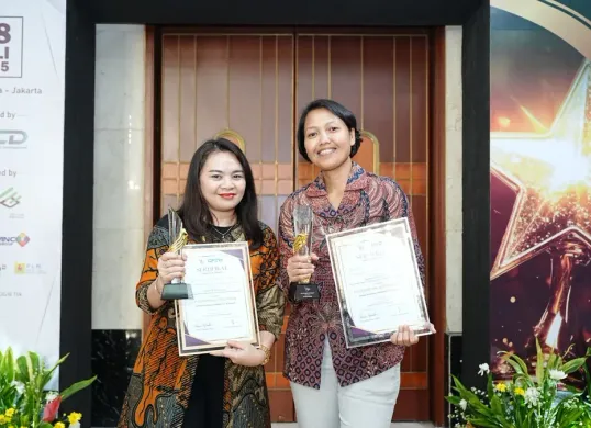 Dua Srikandi PLN UID Jakarta Raya, menunjukkan piala penghargaan yang diraih dalam ajang CESA & BERBAKTI Awards 2025 di Hotel Bidakara Jakarta, Jumat, 18 Juli 2025. (Sumber: Dok. PLN UID Jakarta Raya)