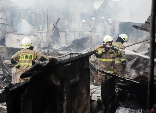 Petugas pemadam kebakaran memadamkan api yang membakar pemukiman padat penduduk di kawasan Grogol Utara, Kebayoran Lama, Jakarta Selatan, Minggu, 20 Juli 2025. (Sumber: Poskota/Bilal Nugraha Ginanjar)