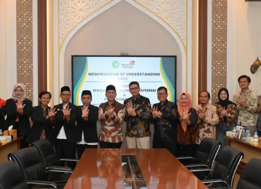 EVP Telkom Regional II Edie Kurniawan dan Ketua Yayasan Waqaf Al Muhajirien Jakapermai Mohammad Syafiudin beserta jajaran dari masing-masing pihak usai penandatanganan MoU, di Bekasi, kemarin. (Sumber: Dok. Telkom)