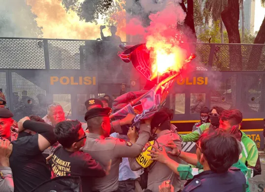 Aksi dorong-dorongan antara massa demo driver ojol dengan aparat kepolisian sempat terjadi di Jalan Medan Merdeka Barat, Jakarta Pusat, Senin, 21 Juli 2025. (Sumber: POSKOTA | Foto: Pandi Ramedhan)