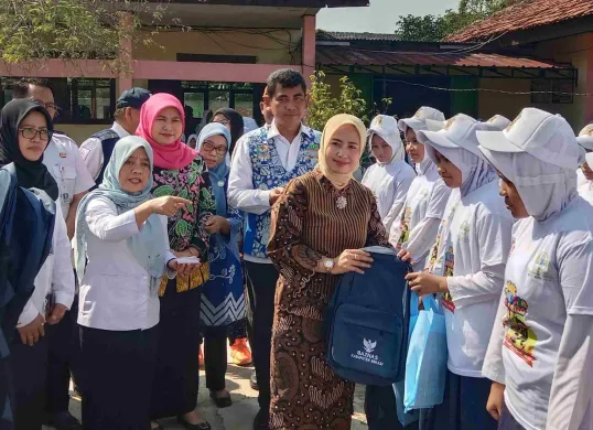 Wakil Bunda Forum Anak Daerah Kabupaten Bekasi, Nia Asep Surya Atmaja memberikan bantuan peralatan sekolah dari Baznas dan Bank Bjb, kepada puluhan siswa, di acara Botram Sekolah dan peringatan HAN di SMAN 1 Tambelang (Sumber: Dok. Pemkab Bekasi)