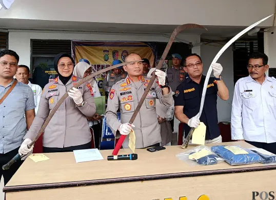 Polres Metro Bekasi Kota menunjukkan barang bukti senjata tajam yang disita dari pelaku tawuran dalam ekspose perkara pada Rabu, 23 Juli 2025. (Sumber: POSKOTA | Foto: Nurpini Aulia Rapika)