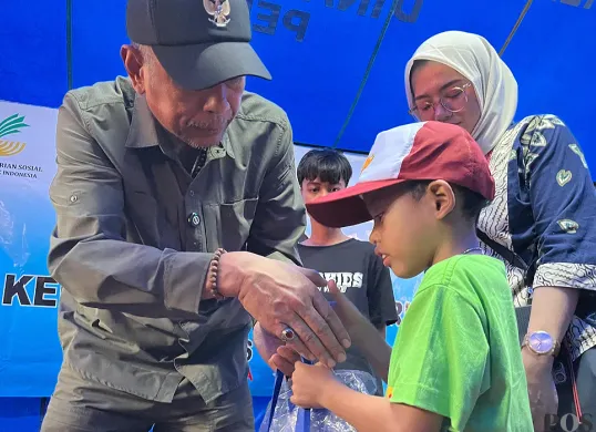 Wakil Menteri Sosial, Agus Jabo Priyono, memberikan bantuan kepada anak terdampak kebakaran di Tambora, Jakarta Barat, pada Kamis, 24 Juli 2025. (Sumber: POSKOTA | Foto: Pandi Ramedhan)