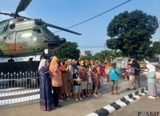 Momen warga mengabadikan diri di depan monumen Helikopter SA-330 Puma di kawasan Stadion Pakansari, Cibinong, Kabupaten Bogor, Jumat, 25 Juli 2025. (Sumber: Poskota/Sekar Putri Andini)