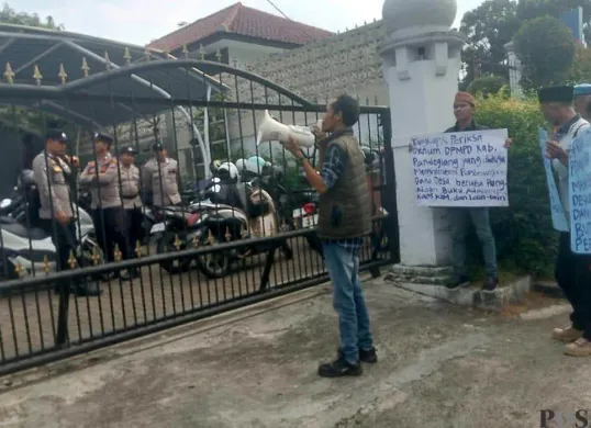 Sejumlah aktivis saat melakukan aksi unjuk rama di depan Kantor DPMPD Pandeglang, terkait belanja buku desa dan kaus KIM. (Sumber: POSKOTA | Foto: Samsul Fatoni)