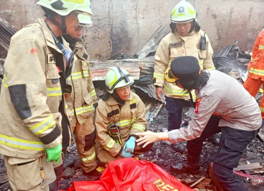 Petugas damkar dan polisi mengevakuasi korban meninggal akibat kebakaran di Gang Kancil I, Lenteng Agung, Jagakarsa, Jakarta Selatan, pada Minggu, 27 Juli 2025. (Sumber: Dok BPBD Jakarta)