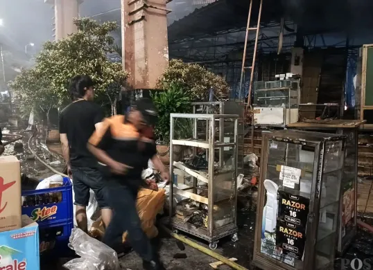 Sejumlah pedagang hanya bisa menyelamatkan sedikit aset mereka saat kebakaran hebat terjadi di Pasar Taman Puring, Jakarta, pada Senin, 28 Juli 2025. (Sumber: POSKOTA | Foto: Ali Mansur)