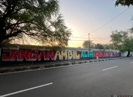 Coretan pada dinding menunjukan penolakan warga Kedoya Selatan terkait wacana alih fungsi lapangan sepak bola menjadi sarana olahraga Padel. (Sumber: Poskota/Pandi Ramedhan)