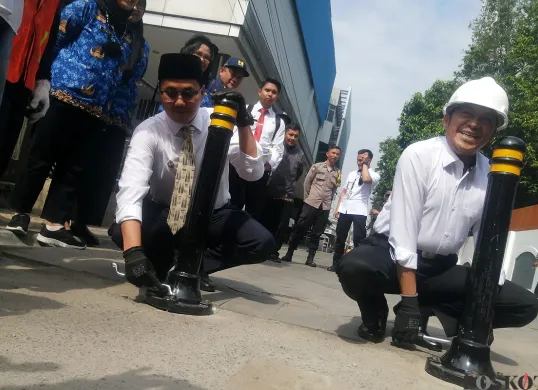 Wali Kota Cimahi, Ngatiyana (kanan), dan Wakil Wali Kota, Adithiya Yudhistira (kiri), memasang tiang pembatas di kawasan Alun-alun timur, Jalan Ria, Senin 2 Juni 2025. (Sumber: POSKOTA | Foto: Gatot Poedji Utomo)