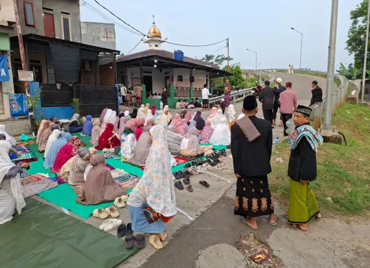 Antusias jemaah Musalah Al - A'Raaf dalam pelaksanaan Solat Idul Adha 1446 Hijriah sampai meluber ke jalan sampai menutup jembatan Fly Over Tol Pamulang - Serpong, Jumat, 6 Juni 2025, pagi. (Sumber: Poskota/Angga Pahlevi)
