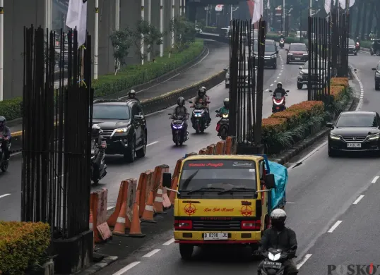 Sejumlah kendaraan melintas di samping deretan tiang pancang monorel yang belum selesai pengerjaannya di Jalan Rasuna Said, Kuningan, Jakarta Selatan. (Sumber: Poskota/Bilal Nugraha Ginanjar)