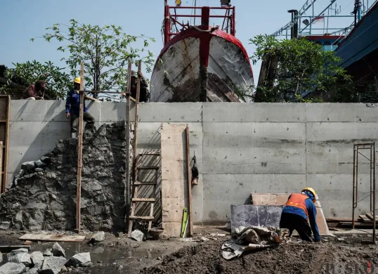 Pekerja menyelesaikan pembangunan tanggul mitigasi di area Docking Kapal Baywalk, Pluit, Jakarta, Kamis, 12 Juni 2025. (Sumber: Poskota/Bilal Nugraha Ginanjar)