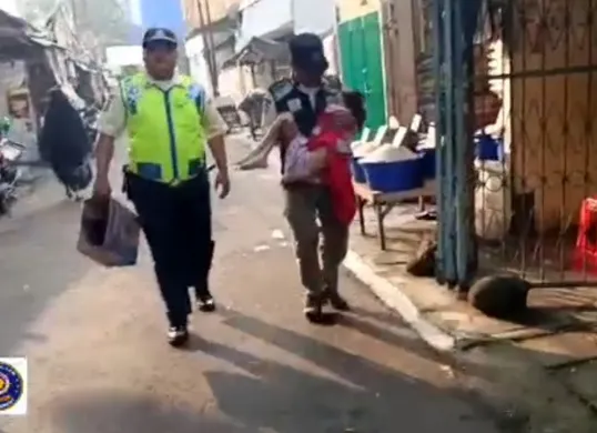 Petugas keamanan Pasar Kebayoran Lama saat mengevakuasi anak perempuan yang ditelantarkan orang tua di lorong pasar.