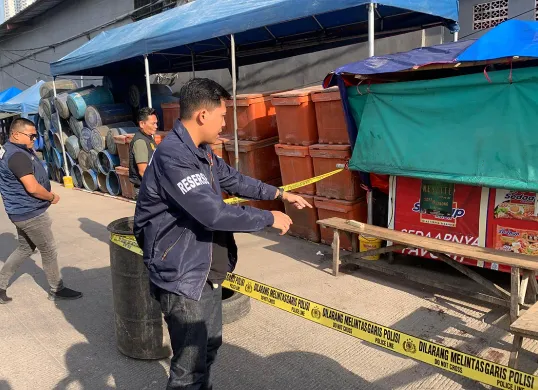 Petugas memasang garis polisi di lokasi pembunuhan seorang pria berinisial ABT, 39 tahun, di kawasan Tempat Pelelangan Ikan (TPI) Muara Angke, Pluit, Penjaringan, Jakarta Utara. (Sumber: Dok Polres Pelabuhan Tanjung Priok)