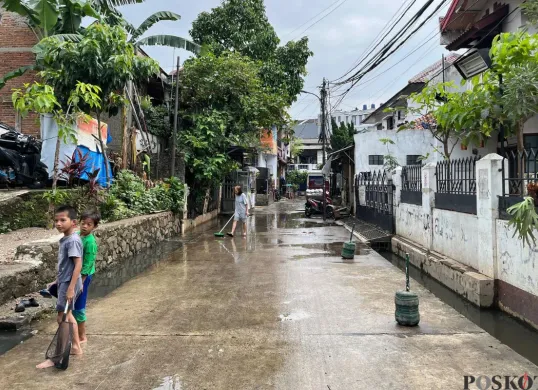 Warga Kelurahan Petogogan, Jakarta Selatan, sedang membersihkan sisa air seusai banjir, Rabu, 18 Juni 2025. (Sumber: Poskota/Pandi Ramedhan)