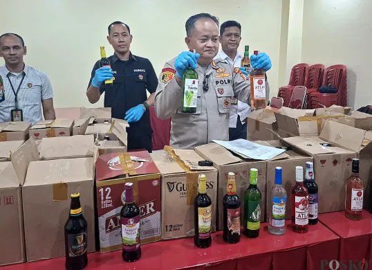 Kapolsek Pancoran Mas AKP Hartono menunjukkan barang bukti ratusan botol miras di sebuah warung jamu dalam Terminal Depok. (Sumber: POSKOTA | Foto: Angga Pahlevi)