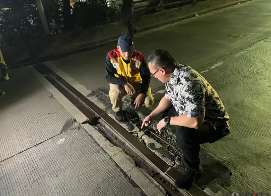 Anggota DPRD Jakarta, Hardiyanto Kenneth, tinjau jalan rusak di Jembatan Dua, Jakarta Utara, Kamis, 19 Juni 2025 malam. (Sumber: Poskota/Pandi Ramedhan)