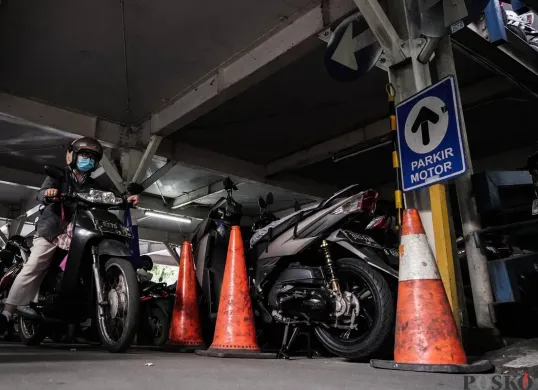 Pengendara mengeluarkan sepeda motor dari area parkir. (Sumber: Poskota/Bilal Nugraha Ginanjar)