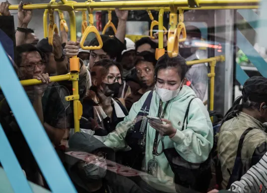 Sejumlah pekerja swasta menunggu kedatangan Transjakarta pada jam pulang kerja di Halte Bundaran HI, Jakarta. (Sumber: Poskota/Bilal Nugraha Ginanjar)