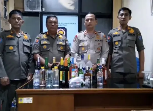 Kapolsek Bojongsari Kompol Fauzan Thohari dengan Kasi Dalops Pol PP Kota Depok Agus menyita miras operasi gabungan dari toko jamu. (Sumber: Dok Polsek Bojongsari)