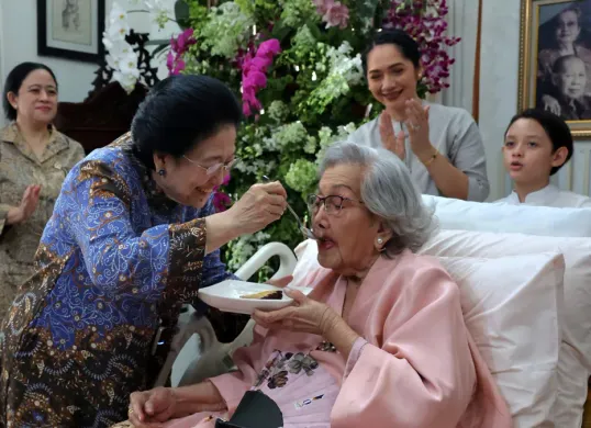 Presiden RI ke-5, Megawati Soekarnoputri menyuapi Meriyati Roeslani, istri mantan Kapolri Jenderal Hoegeng Iman Santoso. (Sumber: Dok PDIP)