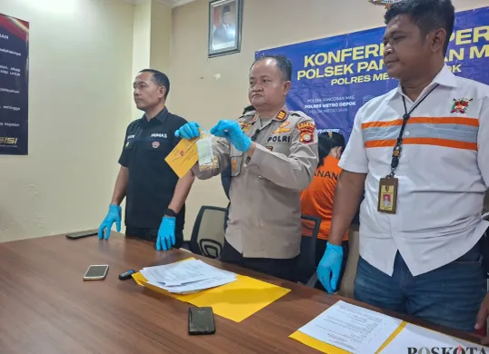 Kapolsek Pancoran Mas AKP Hartono memperlihatkan barang bukti dua gelang perhiasan emas yang dicuri pelaku dari toko perhiasan tempatnya bekerja. (Sumber: Poskota/Angga Pahlevi)