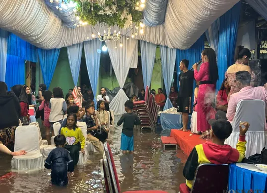 Acara pernikahan warga Muara Angke, Jakarta Utara, tetap berjalan ditengah banjir rob yang melanda, Senin, 23 Juni 2025. (Sumber: Poskota/Pandi Ramedhan)