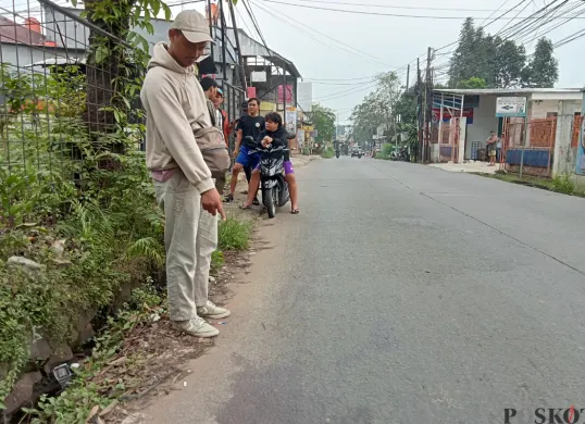 Warga menunjukkan bekas ceceran darah di TKP tawuran antar geng pemuda di Jalan Raya Kodau, Kecamatan Jatiasih, Kota Bekasi. (Sumber: POSKOTA | Foto: Nurpini Aulia Rapika)