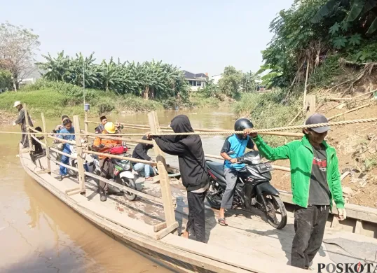 Fadil, 32 tahun, warga gabus pabrik, bersama teman-temannya sedang mengoperasikan perahu eretan untuk menyebrangi kali Bekasi yang menghubungkan daerah Tambun Utara dan Babelan. (Sumber: Poskota/Nurpini Aulia Rapika)