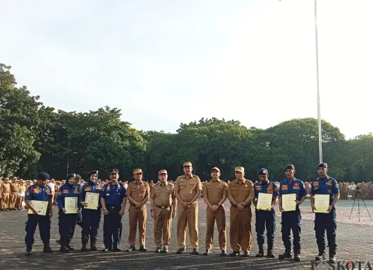 Wali Kota Bekasi, Tri Adhianto, berfoto bersama sejumlah anggota Damkar Kota Bekasi yang menerima penghargaan atas upaya penggagalan aksi bunuh diri ibu muda korban KDRT. (Sumber: Poskota/Nurpini Aulia Rapika)